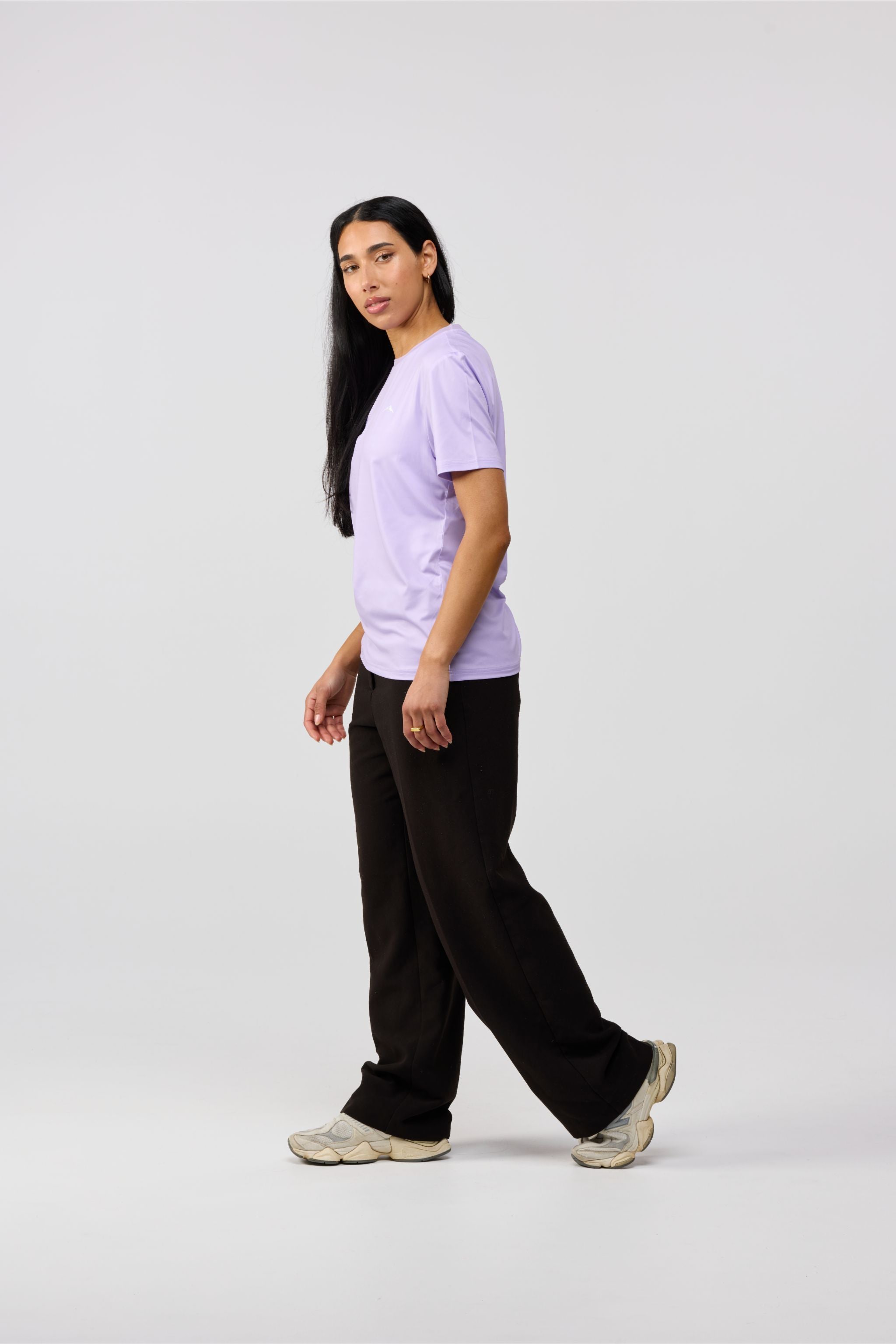 UPF Model wearing a lavender t-shirt and black pants on a white background