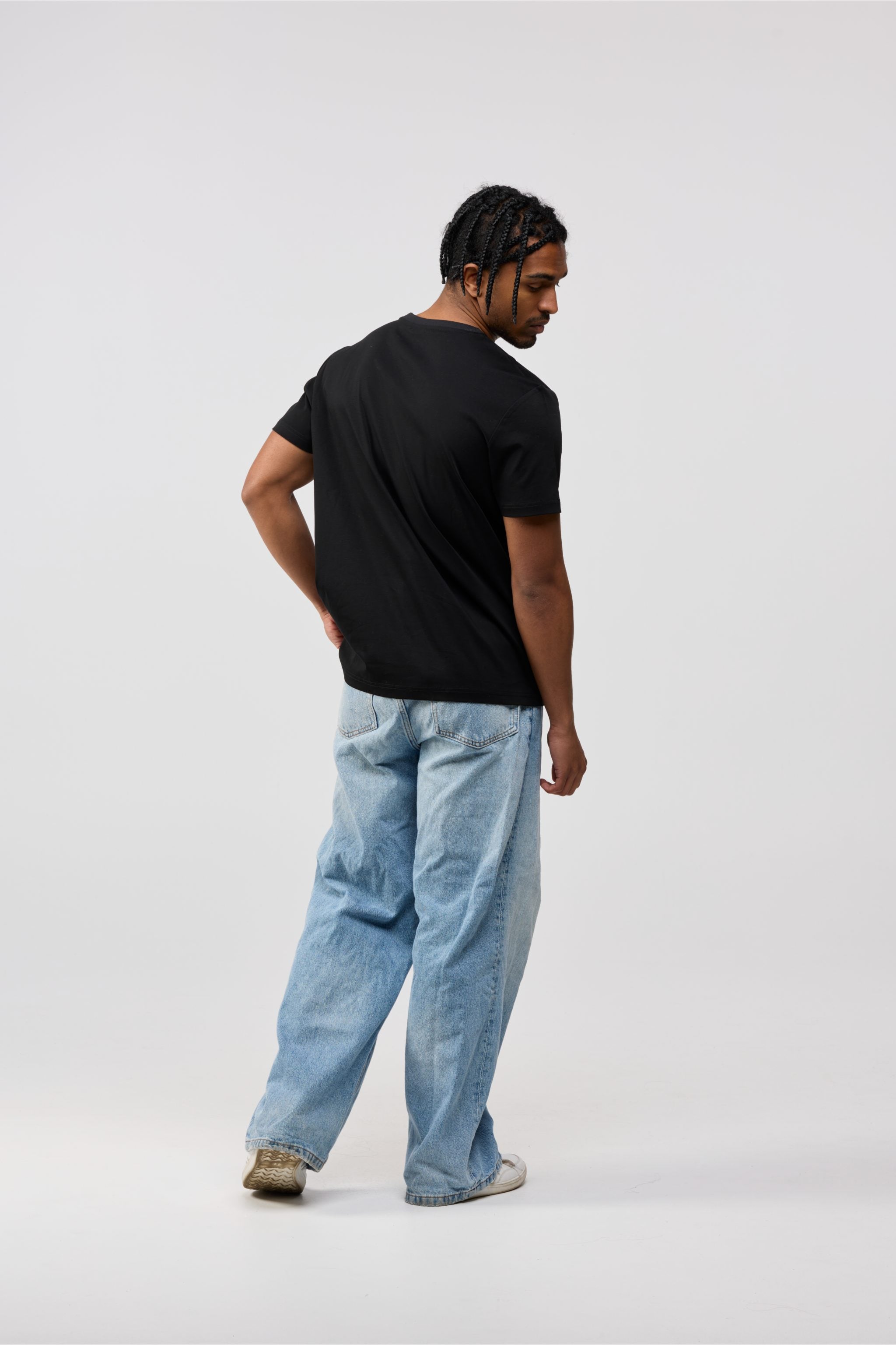 Back view of men’s black cotton crewneck t-shirt with solid black finish.
