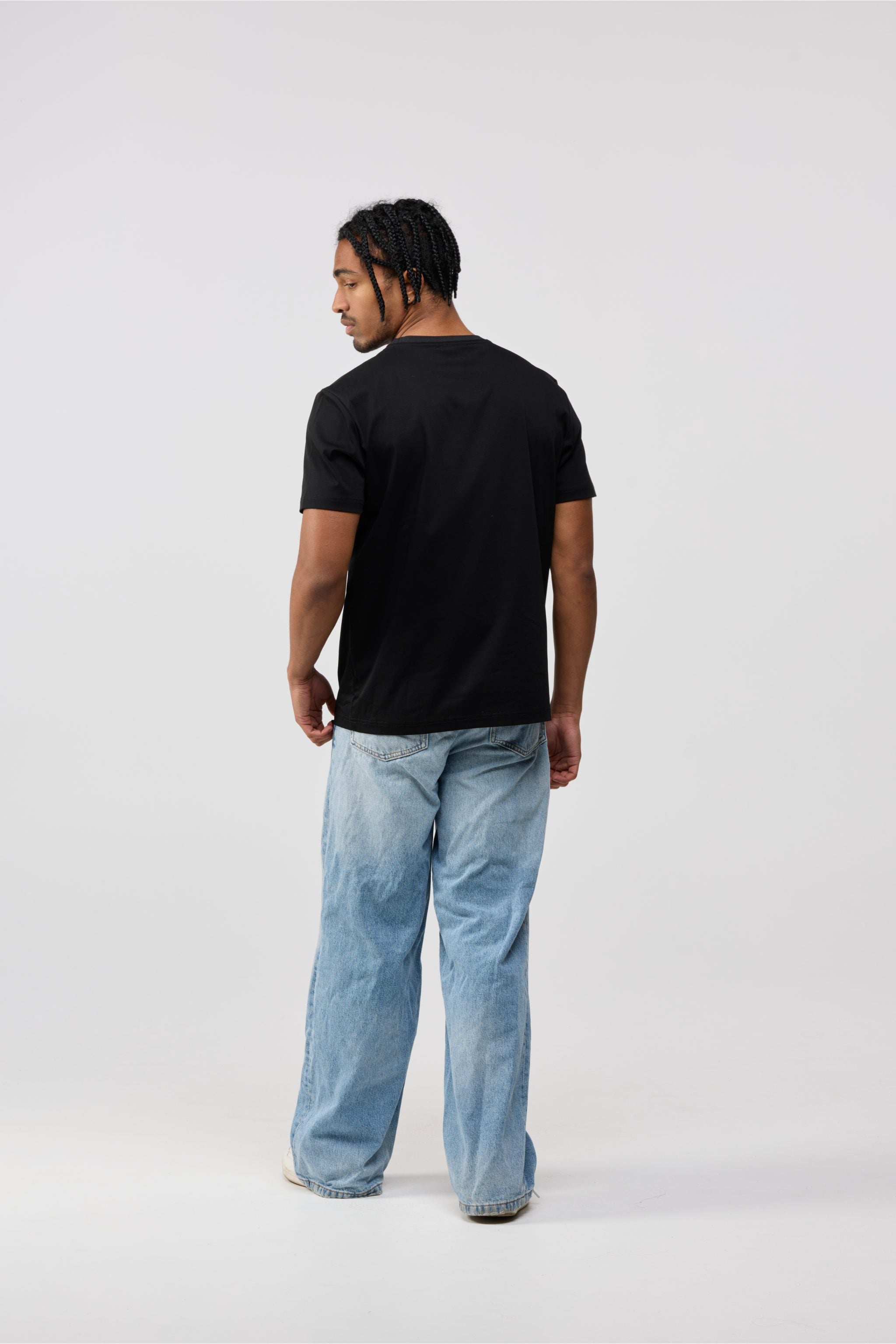 Back view of men’s black cotton crewneck t-shirt with solid black finish.