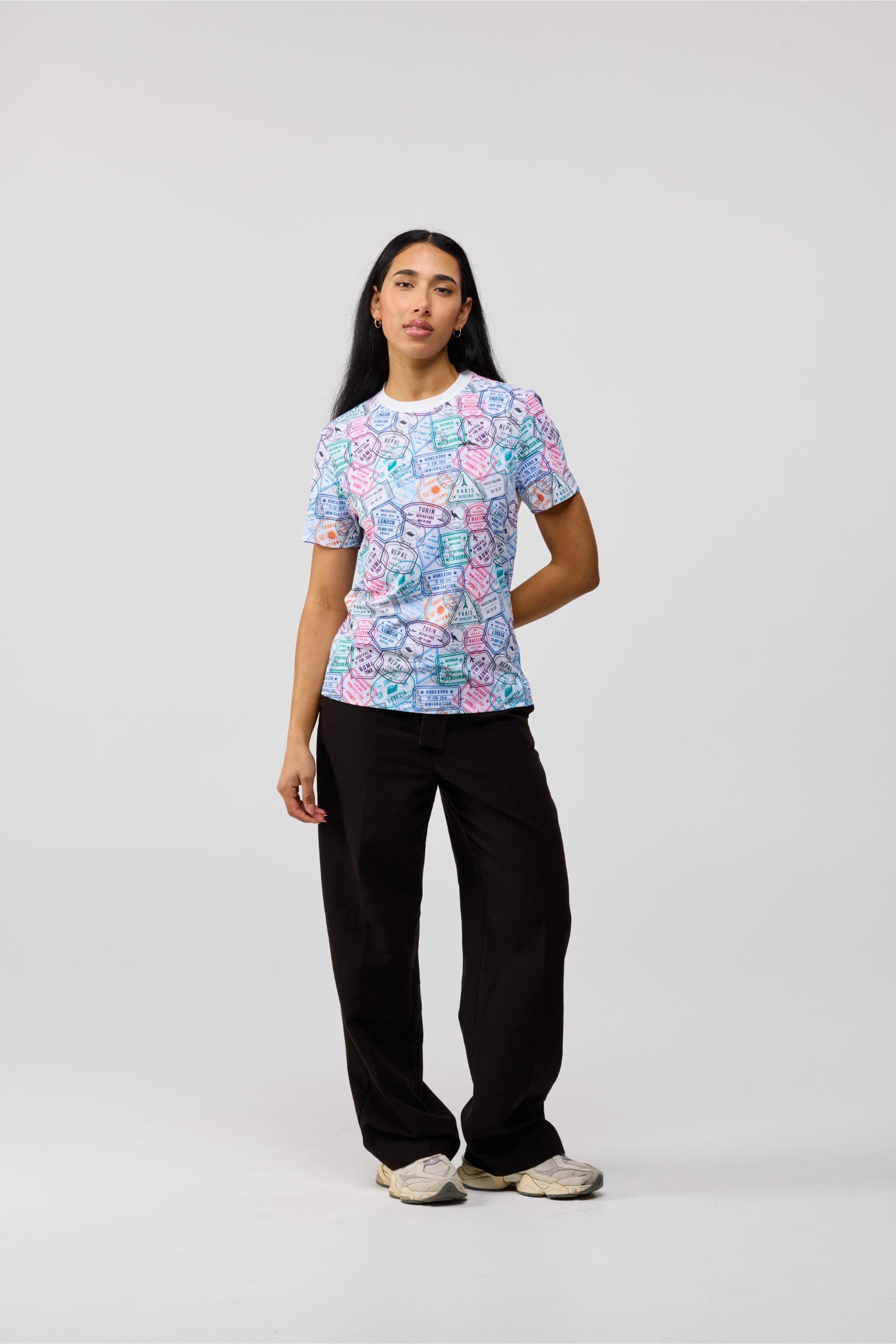 Model seated wearing the Travel Stamp short sleeve shirt, displaying relaxed yet sophisticated style.